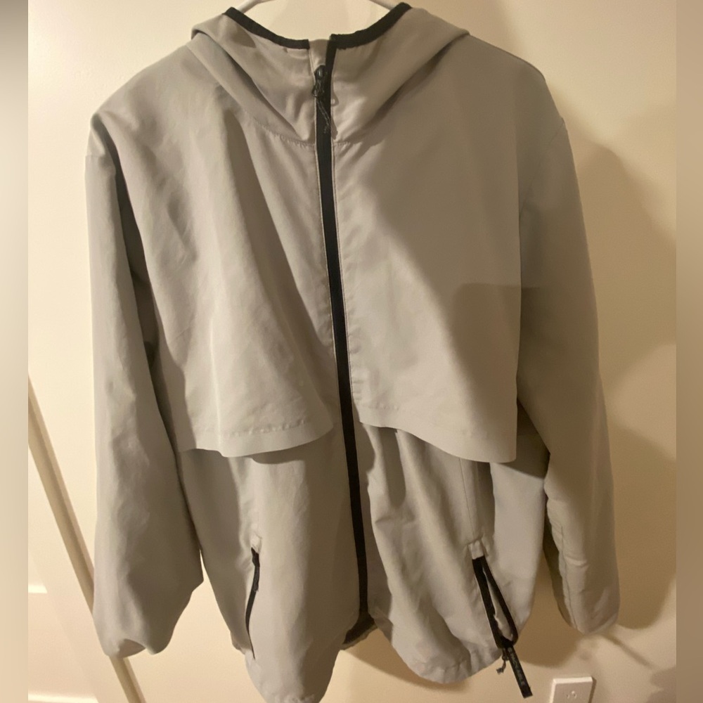White / Gray and black windbreaker jacket that is also packable into the pocket